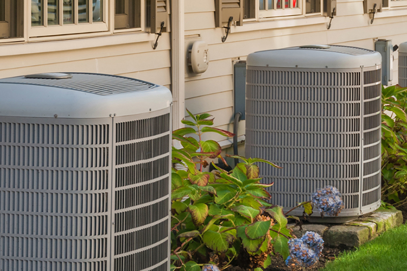 Two HVAC units outside duplex homes.